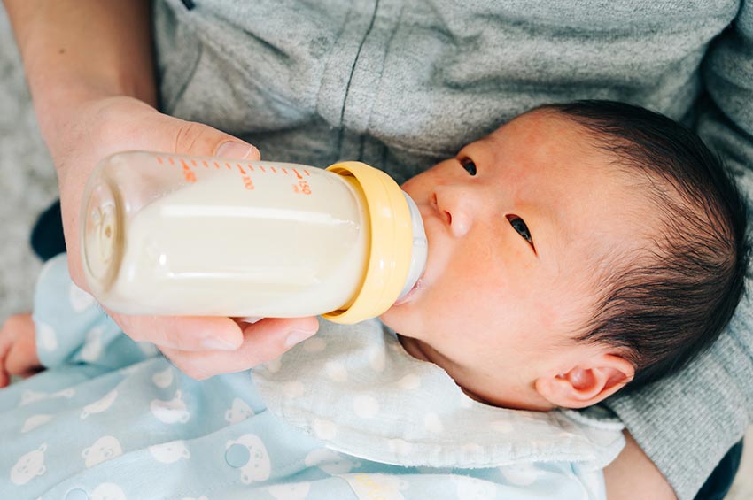 哺乳びんでミルクを飲む赤ちゃん