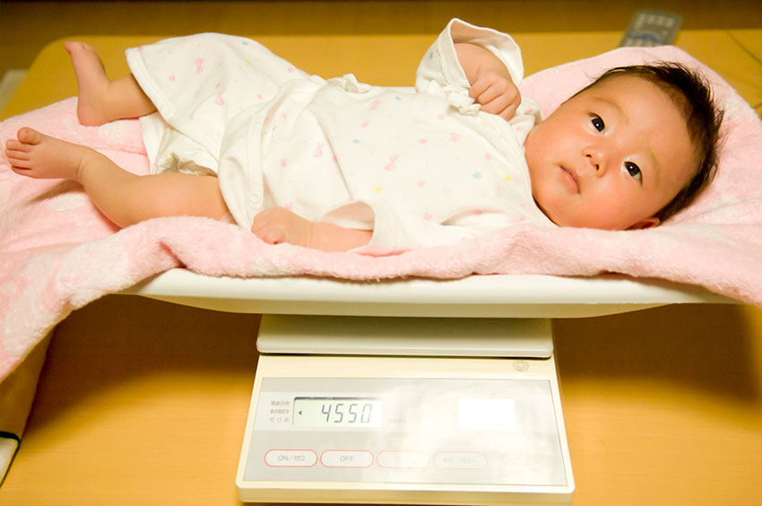 体重測定中の赤ちゃん