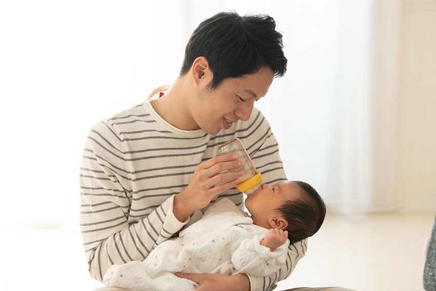 哺乳瓶で赤ちゃんに授乳をするパパ