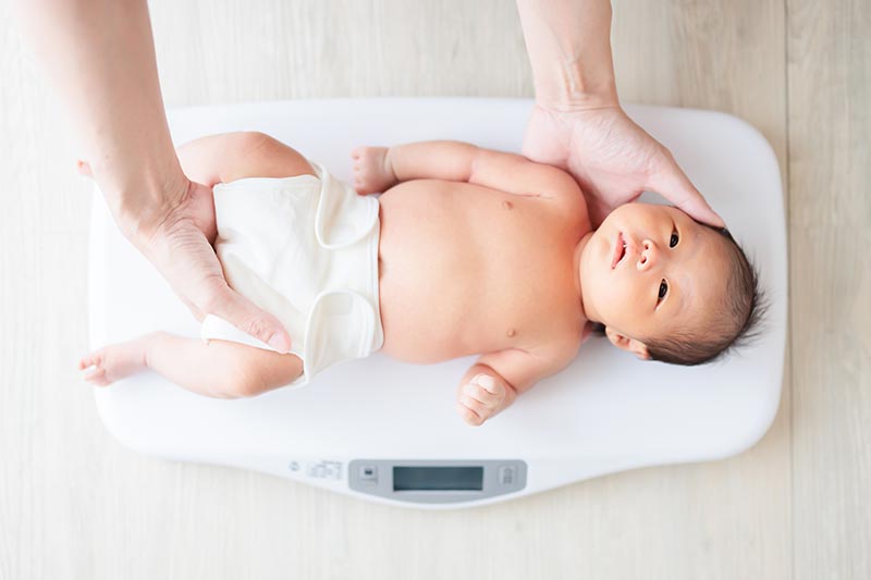 体重測定中の赤ちゃん
