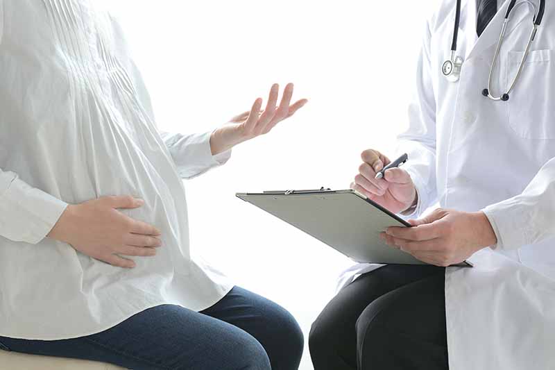 医師と会話する妊婦さん