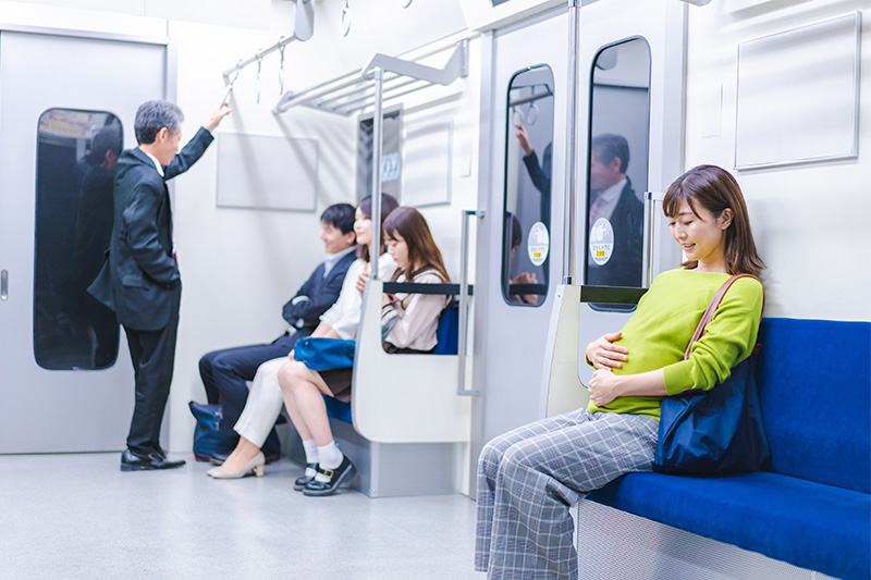 電車の席に座る妊婦さん