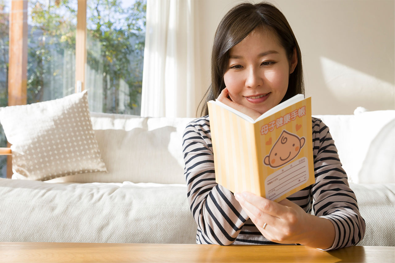 母子手帳を見ている妊婦さん