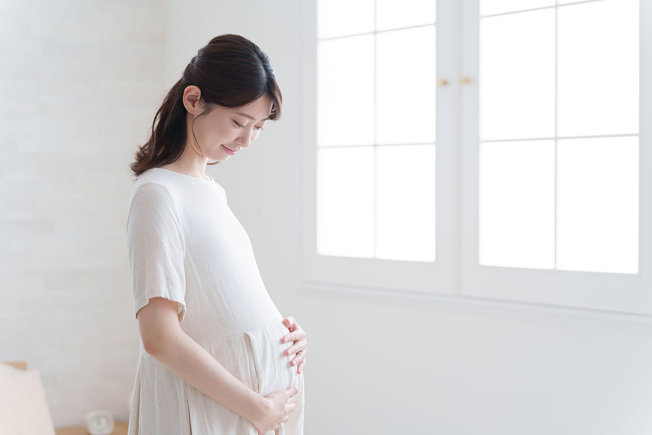 お腹に手をあてる微笑む妊婦さん