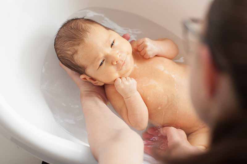 ママの顔を見ている沐浴中の赤ちゃん