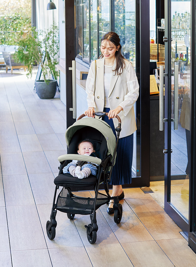 お出かけ先のママとリノンに乗った赤ちゃんの写真